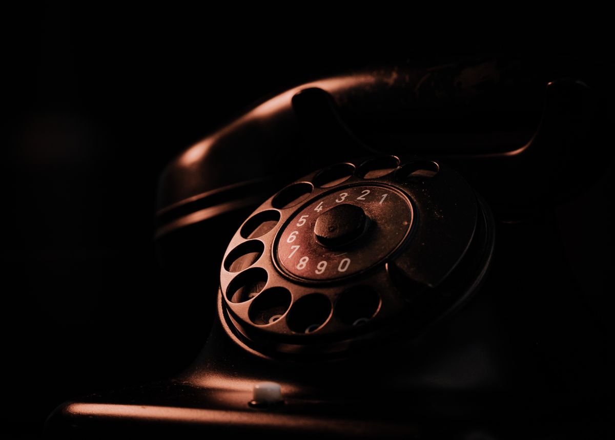 Stary telefon z tarczą w ciepłym świetle